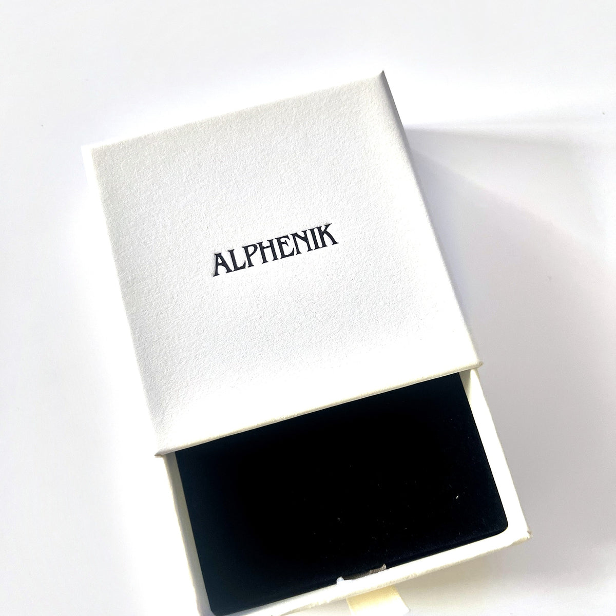 Alphenik gift box, open — black velvet insert